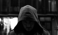 Спортик в темной одежде и капюшоне